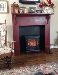 a living room with a fire place in the center and pictures on the wall above it