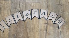 the letters are cut out to spell their name in black and white on a wood floor