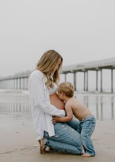 a woman holding a baby on the beach