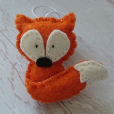 an orange stuffed animal sitting on top of a wooden floor next to a key chain