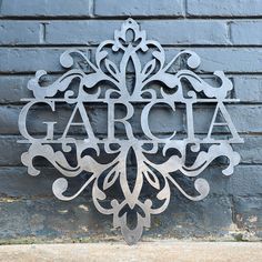 a metal sign with the word garcia on it next to a brick wall in front of a building