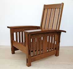 a wooden chair sitting on top of a hard wood floor next to a white wall