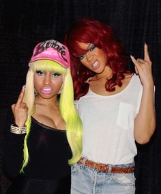 two women dressed in wigs posing for the camera