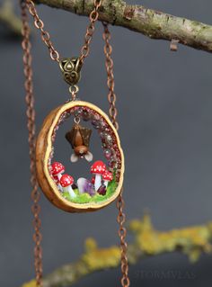 a close up of a necklace on a tree branch with mushrooms in the center and other things inside it