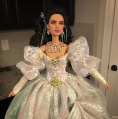 the doll is wearing a green and white dress