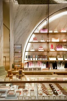 a display case in a store filled with lots of cakes and desserts on shelves