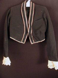 RARE BOY'S SIZE 5 FRENCH BLACK WOOL BOLERO TUXEDO JACKET CIRCA EDWARDIAN-1920'S THIS ITEM IS FROM A LARGE COLLECTION I BOUGHT IN PARIS, FRANCE IN THE 1980'S FOUR COLOR BRAIDED TRIM ON EDGES VERY HIGH QUALITY CUSTOM CONSTRUCTION HEAVY SILK SATIN LINING EYELET LACE 3 INCH TRIM ON SLEEVES (LACE NEEDS BLEACHING) VERY GOOD CONDITION THREE SMALL REPAIRS SIZE 5+ 29 INCH CHEST 15 INCH LENGTH 21 1/2 INCHES CUFF TO SHOULDER SEAM 27 1/2 INCH SLEEVES CUFF TO CENTER COLLAR ALONG THE OUTER EDGE 12 INCHES SHOU Tuxedo Jacket, Eyelet Lace, Black Wool, Up Hairstyles, Silk Satin, Paris France, Yoga Pants, Varsity Jacket, Bomber Jacket