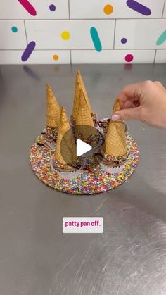 an ice cream cone with sprinkles is being held up by someone's hand