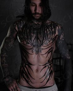 a man with long hair and tattoos on his chest