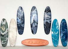 five surfboards lined up against a white wall