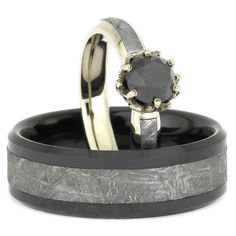 two wedding rings with black and white diamonds on each one, set in gold and silver