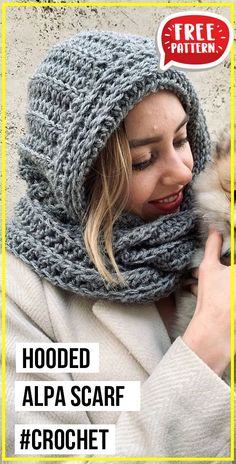 a woman holding a small dog wearing a knitted hat and scarf over her face