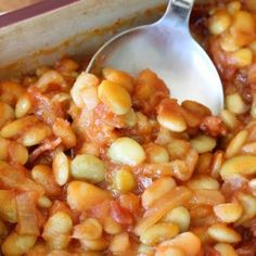 a spoon in a dish filled with beans