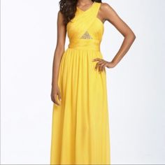 a woman in a long yellow dress posing for the camera with her hands on her hips