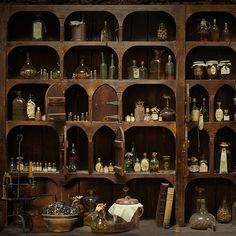 an old wooden shelf filled with lots of bottles