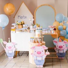 a birthday party with balloons, decorations and animals on the table in front of it