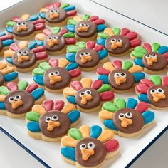 decorated cookies in the shape of turkeys are on a white tray with blue trim