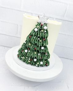 a small green christmas tree on top of a white plate