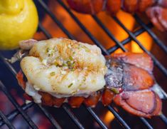 lobsters are cooking on the grill with lemons