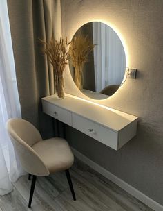 a white chair sitting next to a table with a mirror on it's side