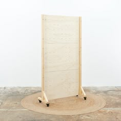 a wooden stand with wheels on it in front of a white wall and carpeted floor