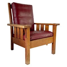 a wooden chair with red leather seat cushion