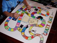 a young boy is playing a board game with his hands on the board and writing