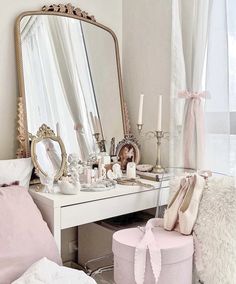 a dressing table with a mirror, stool and candles