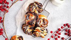 cinnamon rolls with icing and sprinkles on a plate next to berries