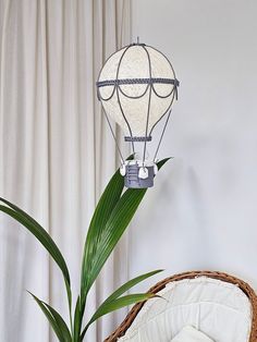 a basket with a plant in it next to a lamp