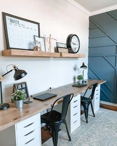 a desk with two chairs and a clock on the wall above it in a home office