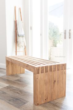 a wooden bench sitting on top of a hard wood floor