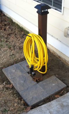 a yellow hose is connected to a black pole