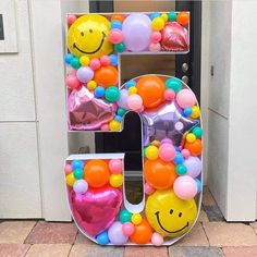 the letter e is made up of balloons and smiling face decorations on it's front door