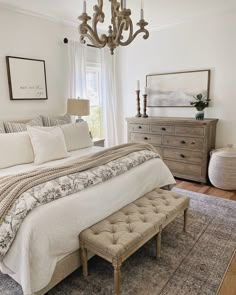 a bedroom with a large bed and a chandelier hanging from it's ceiling