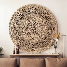 an intricately carved wooden wall hanging in a living room with two couches and a coffee table