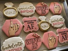 decorated cookies in the shape of wedding rings and groom's names are displayed on a tray