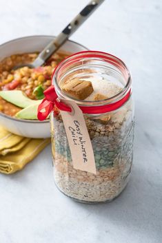 a glass jar filled with food next to a spoon