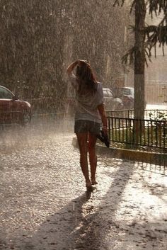 a woman walking in the rain with an umbrella