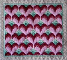 a crocheted blanket with red, green and pink designs on the bottom half