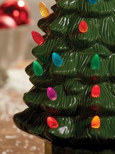 a green ceramic christmas tree with multi colored lights