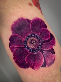 a purple flower tattoo on the right thigh