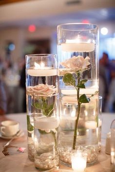 two vases filled with flowers and candles on top of a table