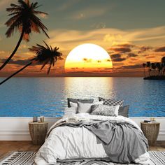 the sun is setting over the ocean with palm trees in front of it and a boat on the water