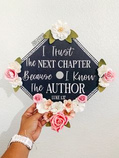 a person holding up a graduation cap with flowers on it that says, i trust the next charter because i know the author