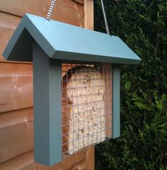 a bird feeder hanging from the side of a house