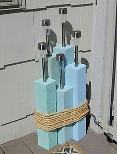 an outdoor sculpture made out of blocks and rope on the ground next to a door