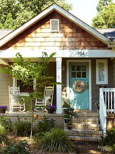 an old photo of a small house with rocking chairs on the front steps and porch