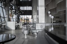 the interior of a modern restaurant with large windows and metal tables, stools and chairs