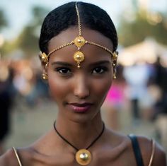 a woman wearing a gold head piece and necklace